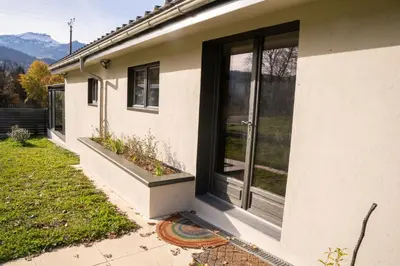 a house with a large window on the side of it at Maison nature, ski, randos in Passy