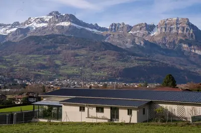 a white house with mountains in the background at Maison nature, ski, randos in Passy