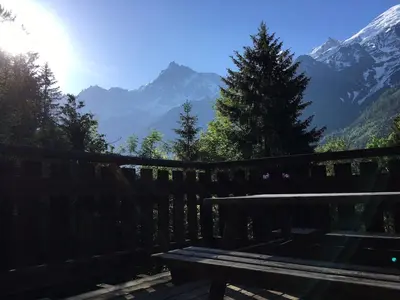 a bench sitting on a deck with a view of mountains at Petite Floria in Les Houches