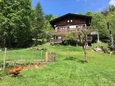 a house on a hill with a fence in the grass at Petite Floria in Les Houches
