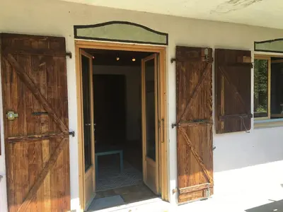an open door in a room with two wooden doors at Petite Floria in Les Houches