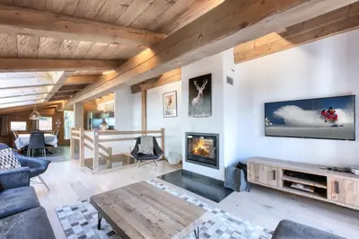 a living room with a couch and a fireplace at Le Cédron, demi-chalet centre pièton Megève in Megève