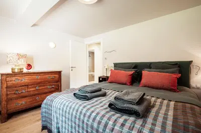 a bedroom with a bed with red pillows and a dresser at Chalet Mont Plaisir - Au pied des Drus in Chamonix-Mont-Blanc