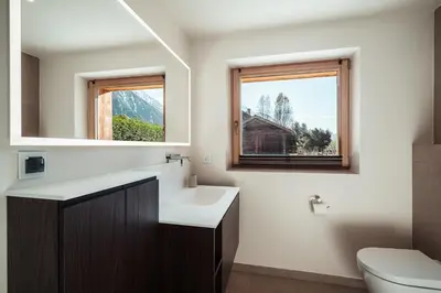 a bathroom with a sink and a toilet and a window at Chalet Mont Plaisir - Au pied des Drus in Chamonix-Mont-Blanc