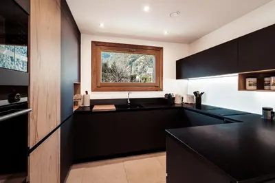 a kitchen with black counters and a window at Chalet Mont Plaisir - Au pied des Drus in Chamonix-Mont-Blanc