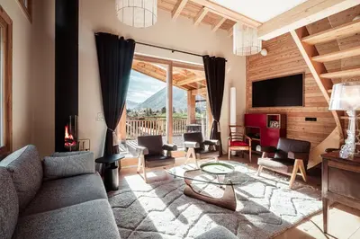 a living room with a couch and chairs and a television at Chalet Mont Plaisir - Au pied des Drus in Chamonix-Mont-Blanc