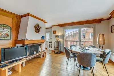 a dining room with a table and a fireplace at Appartement Mercier - Welkeys in Megève