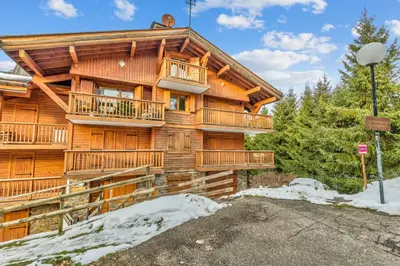 a log cabin in the woods with snow on the ground at Appartement Mercier - Welkeys in Megève