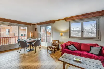 a living room with a red couch and a table at Appartement Mercier - Welkeys in Megève
