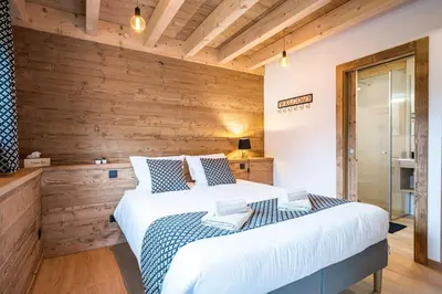 a bedroom with wooden walls and a large bed at L'Eterle - Grand chalet avec terrasse et jardin in Les Contamines-Montjoie