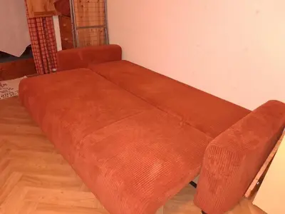 a brown couch sitting in a corner of a room at Studio SnowCarroz with a view for 4 people in Arâches-la-Frasse