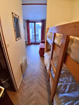 a living room with a red couch and a table at Studio SnowCarroz with a view for 4 people in Arâches-la-Frasse