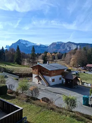 a living room with a red couch and a table at Studio SnowCarroz with a view for 4 people in Arâches-la-Frasse
