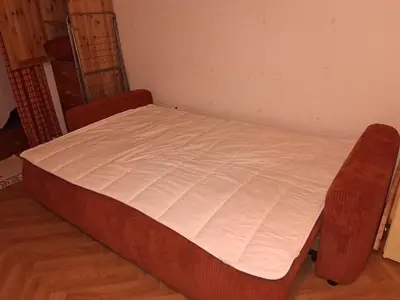 a brown bed sitting in the corner of a room at Studio SnowCarroz with a view for 4 people in Arâches-la-Frasse