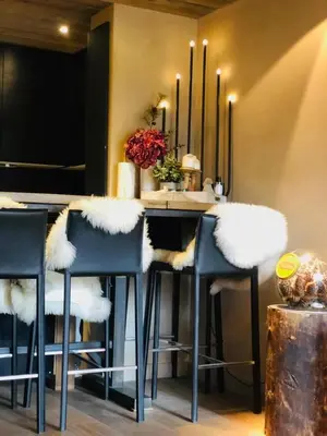 a kitchen with a bar with blue chairs and a table at Cimes Lodge - Wood & Mountain in Demi-Quartier