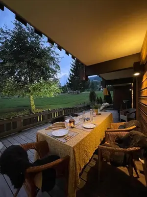 a table with a yellow table cloth on a patio at Cimes Lodge - Wood & Mountain in Demi-Quartier
