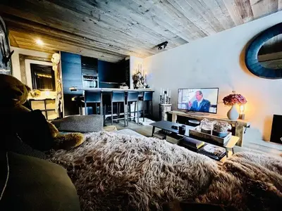 a living room with a large bed and a kitchen at Cimes Lodge - Wood & Mountain in Demi-Quartier