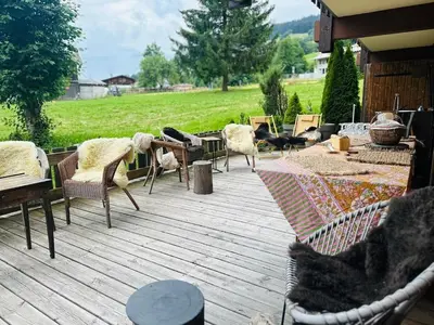 a patio with chairs and tables on a wooden deck at Cimes Lodge - Wood & Mountain in Demi-Quartier