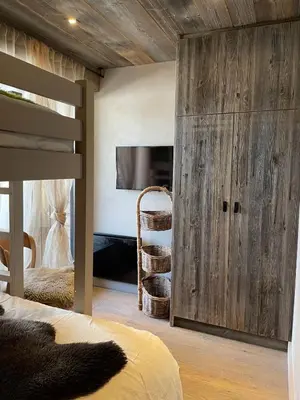 a bedroom with a bunk bed with a wooden wall at Cimes Lodge - Wood & Mountain in Demi-Quartier
