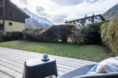 a suitcase sitting on a deck with a view of a house at Capucins in Chamonix-Mont-Blanc