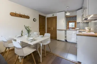 a kitchen and dining room with a white table and chairs at Capucins in Chamonix-Mont-Blanc