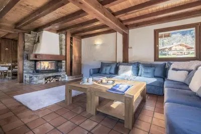 a living room with a blue couch and a table at Chalet Cusco in Servoz
