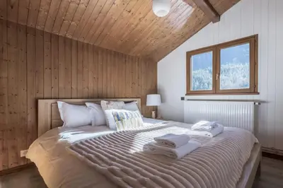 a bedroom with a large bed with towels on it at Chalet Cusco in Servoz