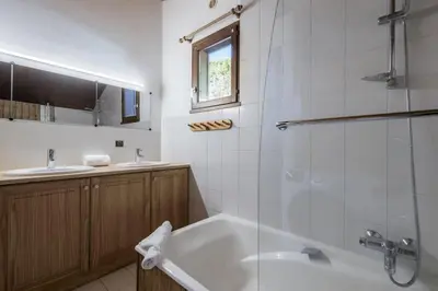 a bathroom with a tub and a glass shower at Chalet Cusco in Servoz