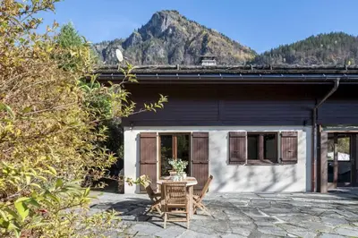 a patio with a table and chairs in front of a house at Chalet Cusco in Servoz
