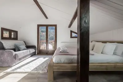 a living room with a bed and a couch at Chalet Cusco in Servoz