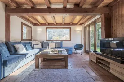 a living room with a blue couch and a table at Chalet Cusco in Servoz