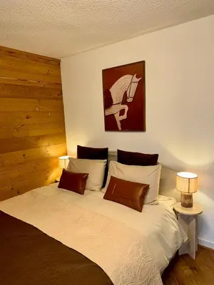 a bedroom with a large white bed with two lamps at LiHam Alpine Suite in Megève