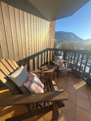 a balcony with benches and a view of the city at LiHam Alpine Suite in Megève
