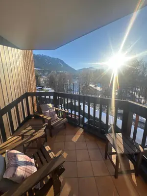 a balcony with benches and a view of the mountains at LiHam Alpine Suite in Megève