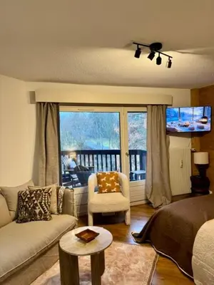 a living room with a couch and a chair at LiHam Alpine Suite in Megève