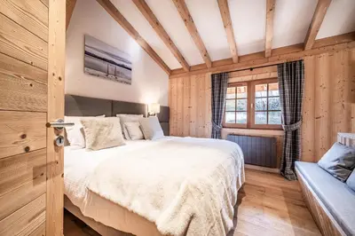 a bedroom with a large bed and a window at Apartment Snowdust Megève - by EMERALD STAY in Megève