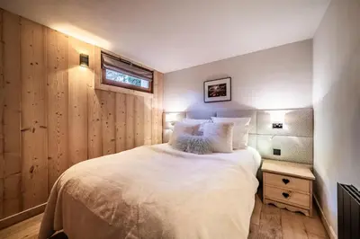 a bedroom with a large white bed and a window at Apartment Snowdust Megève - by EMERALD STAY in Megève