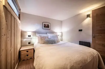 a bedroom with a large bed with white sheets at Apartment Snowdust Megève - by EMERALD STAY in Megève