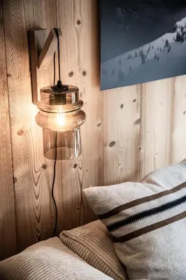 a lamp sitting next to a bed in a room at Apartment Snowdust Megève - by EMERALD STAY in Megève
