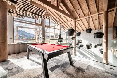 a pool table in a room with a large window at Apartment Spritz Megève - by EMERALD STAY in Megève
