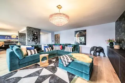 a living room with a blue couch and a chandelier at Apartment Spritz Megève - by EMERALD STAY in Megève