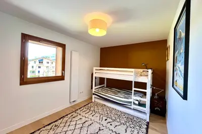 a bedroom with a bunk bed and a window at Bright apartment with balcony and stunning views in Megève