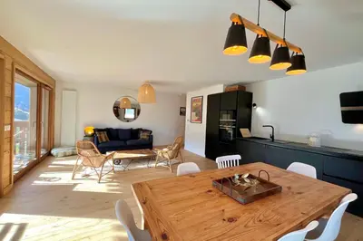 a kitchen and living room with a wooden table at Bright apartment with balcony and stunning views in Megève