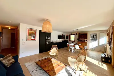 a living room with a couch and a dining room at Bright apartment with balcony and stunning views in Megève