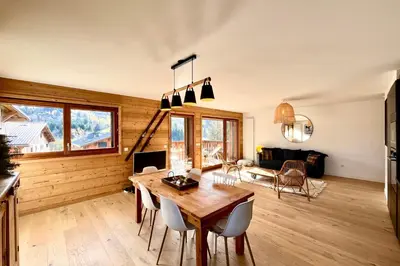 a living room with a wooden table and chairs at Bright apartment with balcony and stunning views in Megève
