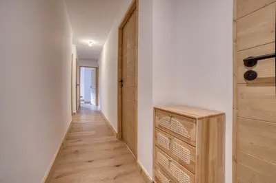 a hallway with a wooden door and a wooden floor at Cosmiques A203 - New & Mont Blanc view in Les Houches