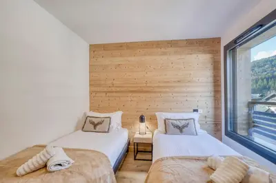 two beds in a room with a window at Cosmiques A203 - New & Mont Blanc view in Les Houches