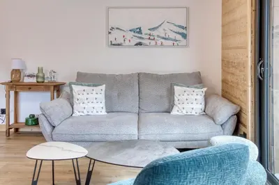 a living room with a couch and a table at Cosmiques A203 - New & Mont Blanc view in Les Houches