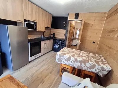 a small kitchen with a table and a refrigerator at Armancette B7 in Les Contamines-Montjoie