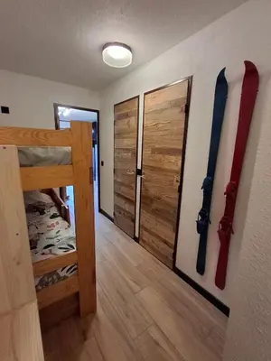 a room with a bunk bed and a door with skis on the wall at Armancette B7 in Les Contamines-Montjoie